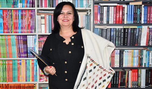 Omzuna astığı çantasındaki kitapları öğrencilere ulaştırıyor